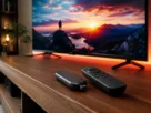 Dispositivo Fire Stick 4K Max com controle remoto sobre rack de madeira em sala com TV ligada