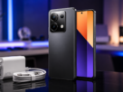 Celular redmi note 13 pro exibindo módulo de câmeras traseiro sobre superfície reflexiva ao lado de carregador rápido de sessenta e sete watts