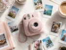 Dispositivo fotografico do tipo camera instax mini 12 rosa cercado por fotos instantaneas reveladas sobre mesa de madeira
