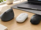 Aparelhos de informática do tipo mouse wireless logitech organizados sobre mesa de trabalho moderna de escritório